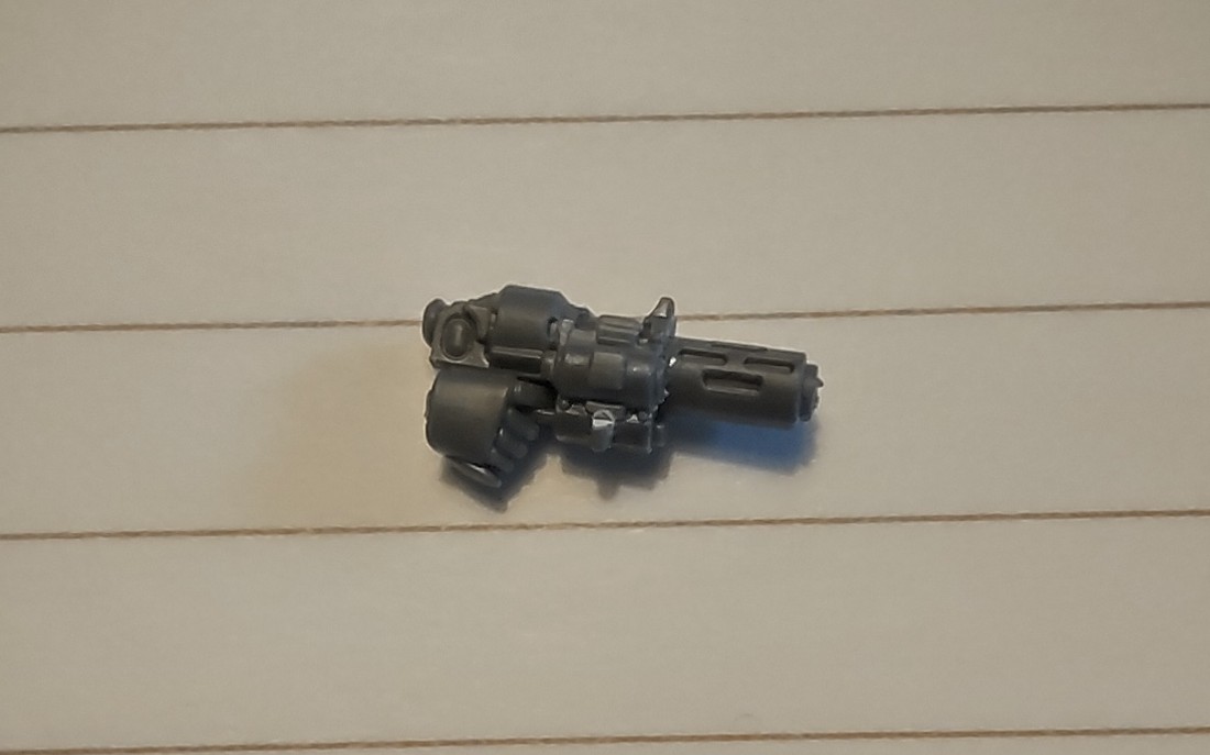 A photo of a kitbashed inferno pistol on a piece of ruled paper.